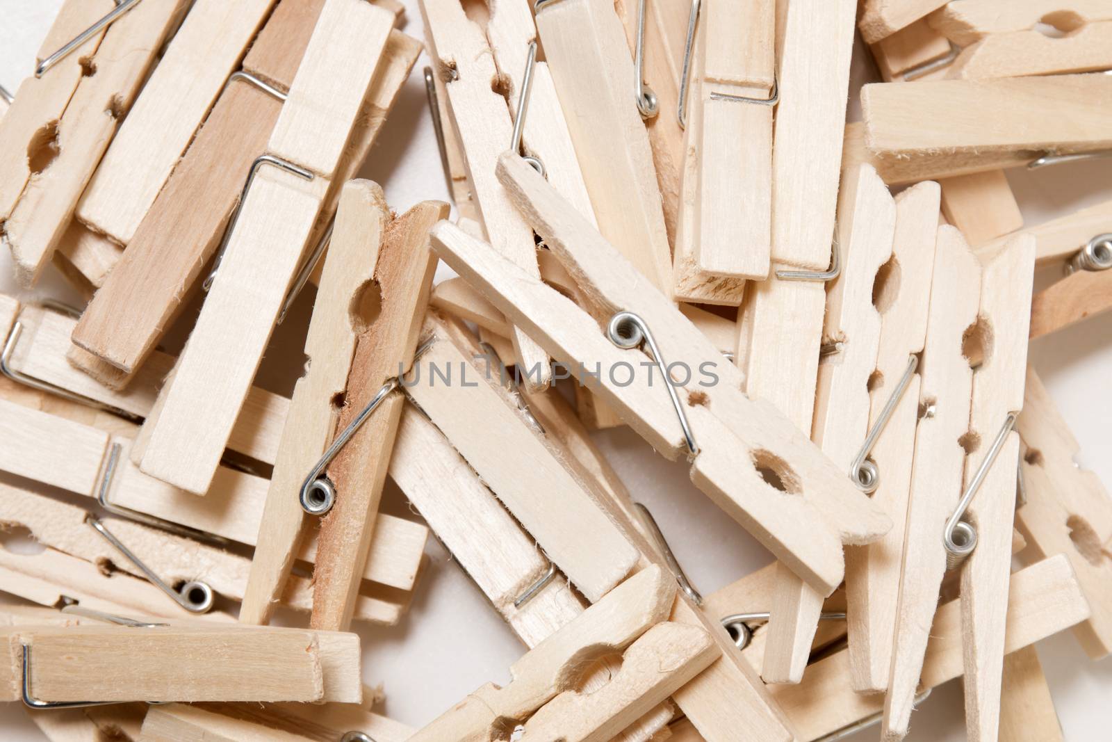 Pile of clothing pegs isolated on a white background.