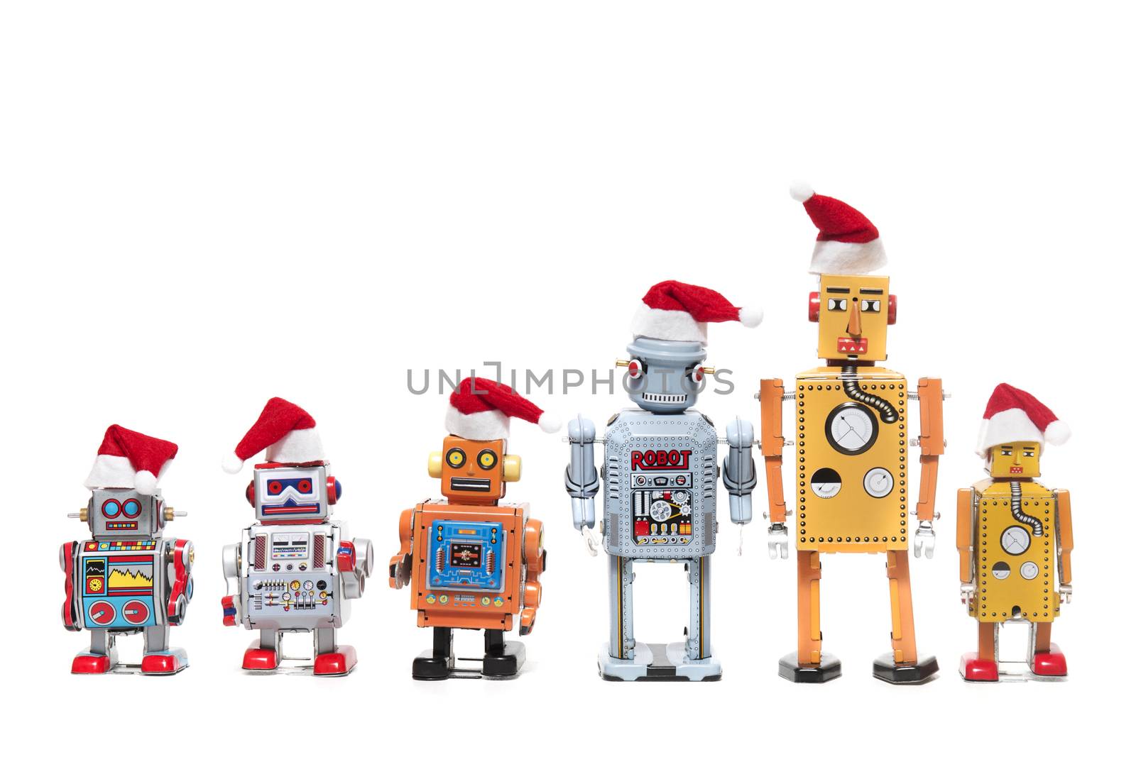 Vintage tin robot toys with xmas hats isolated on a white background.