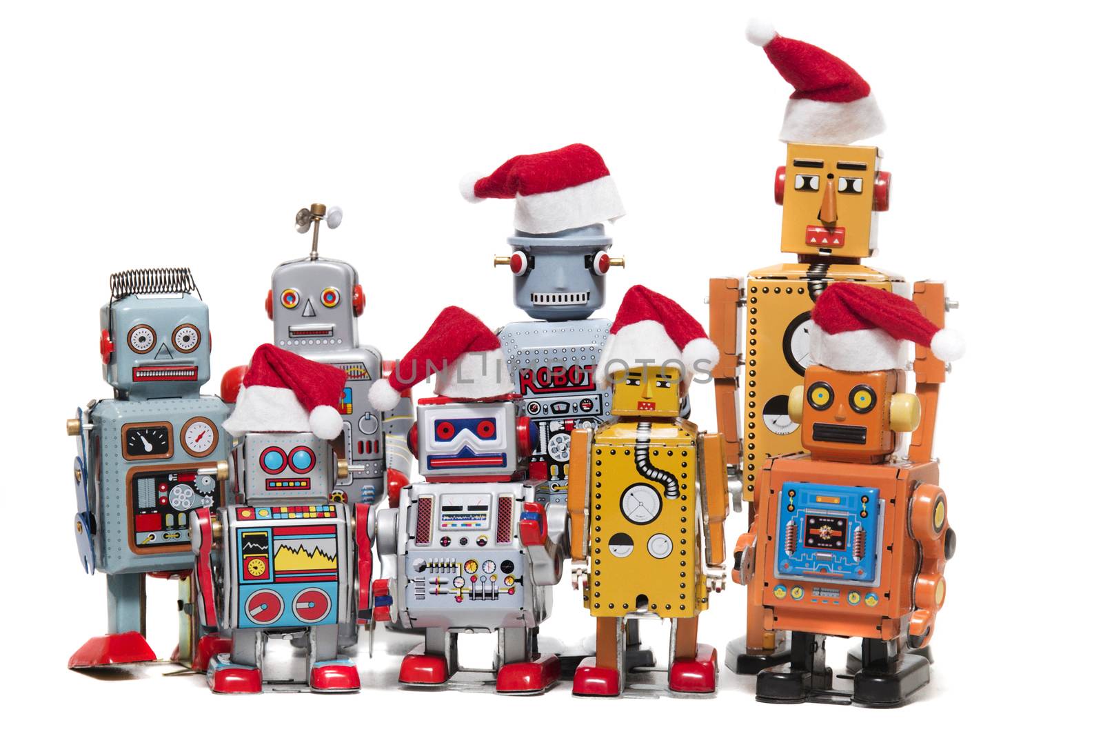 Vintage tin robot toys with xmas hats isolated on a white background.