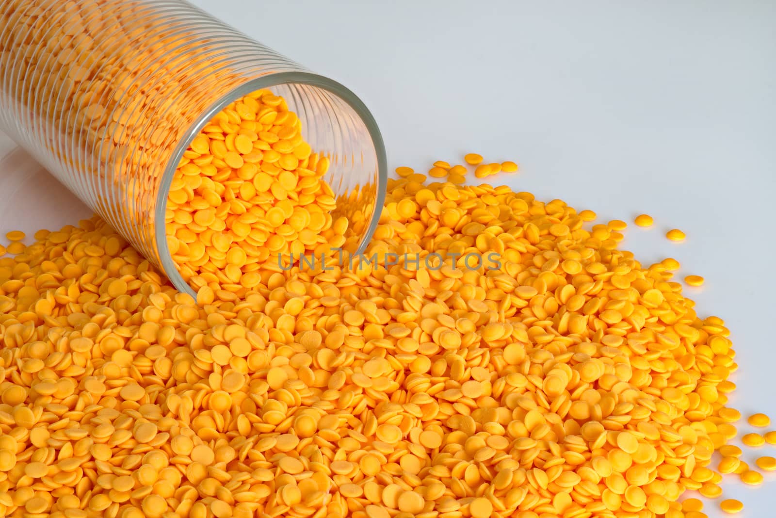 Polypropylene beads, plastic orange pellets on white color background.