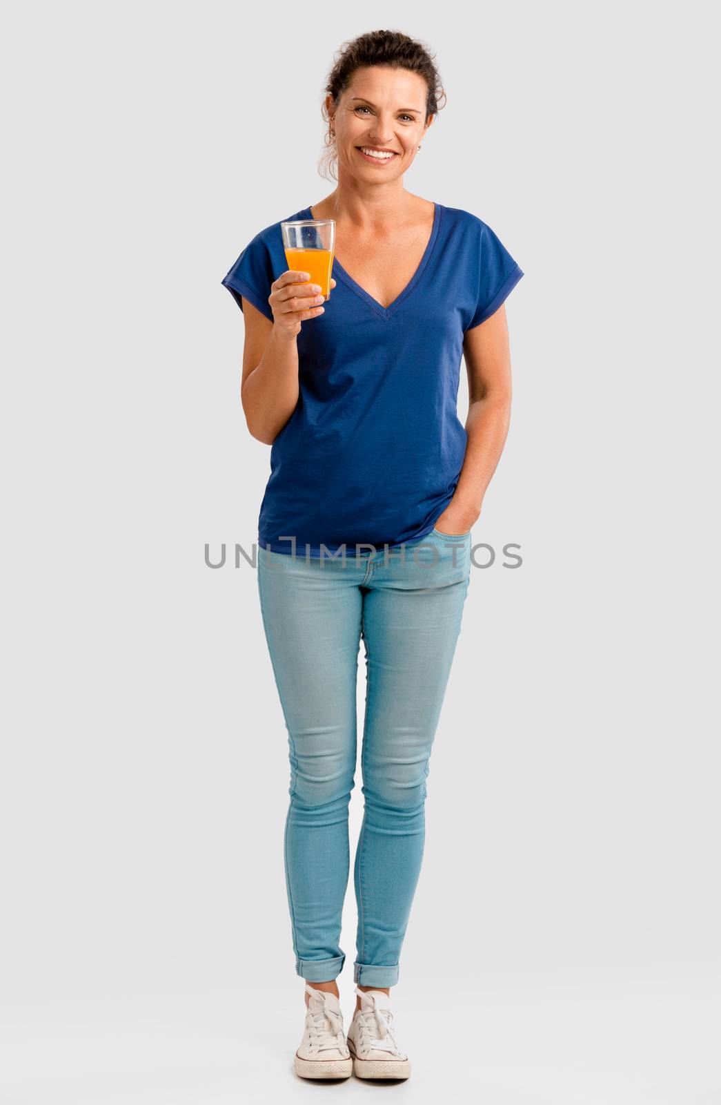 Middle aged woman holding a glass with orange juice