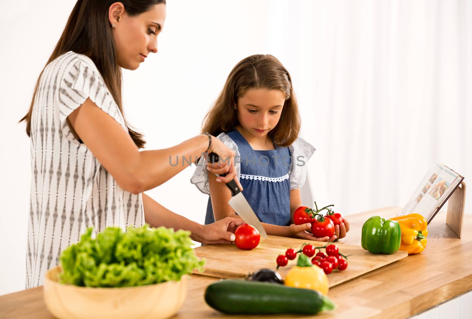 Shot of a mother and daughter having fun in the kitchen