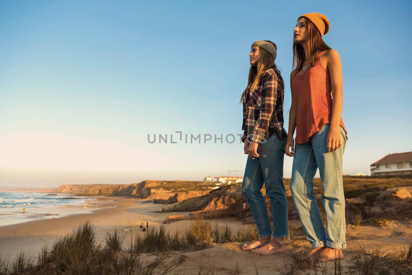 Two best friends near the coastline looking to the sea