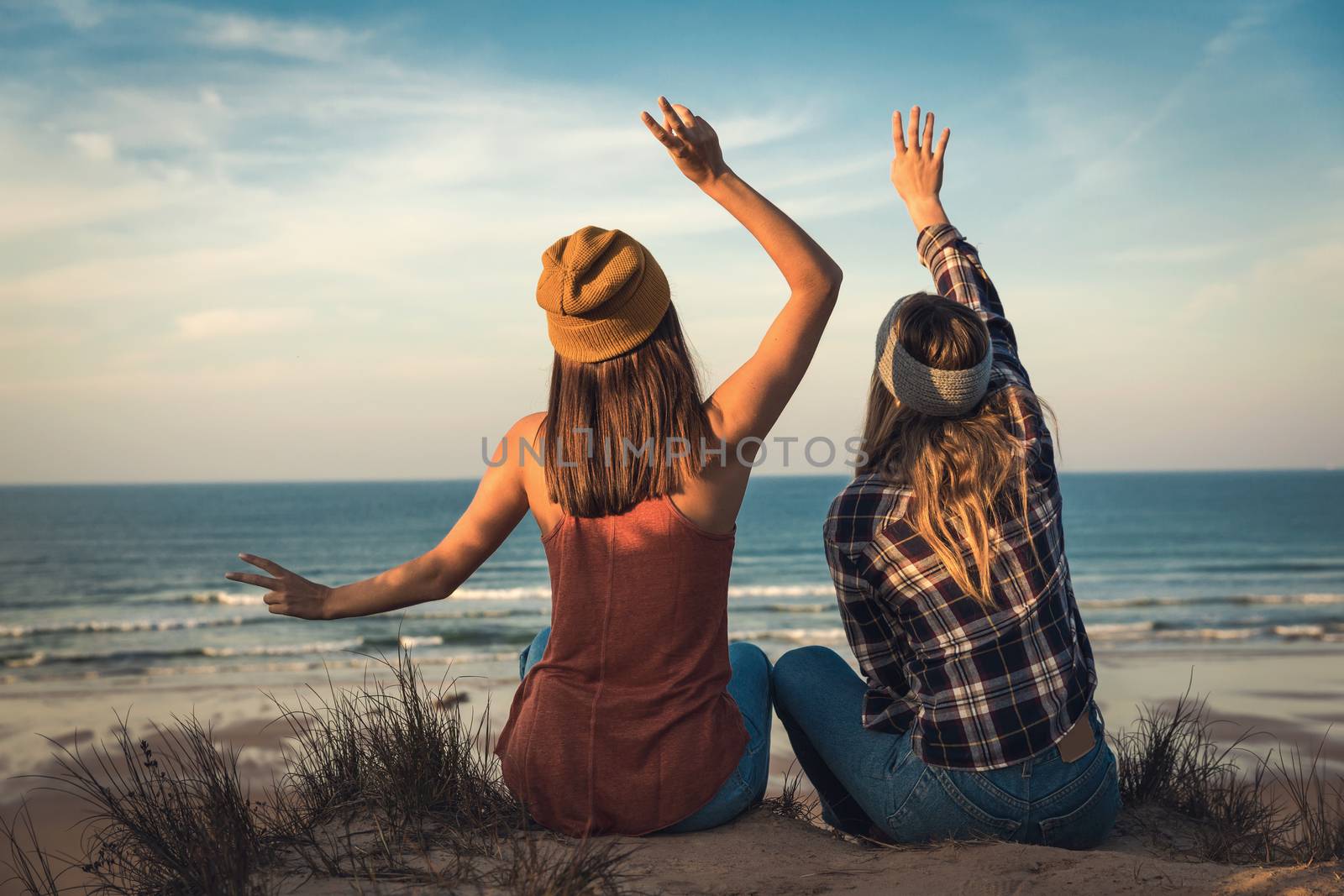 Two best friends sitting on the coastline having a good time