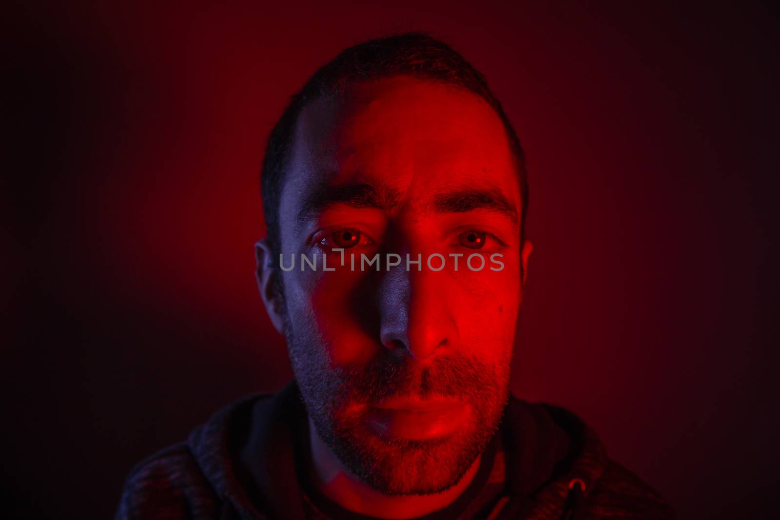 Man with serious facial expression. Close up portrait of expressionless young man.