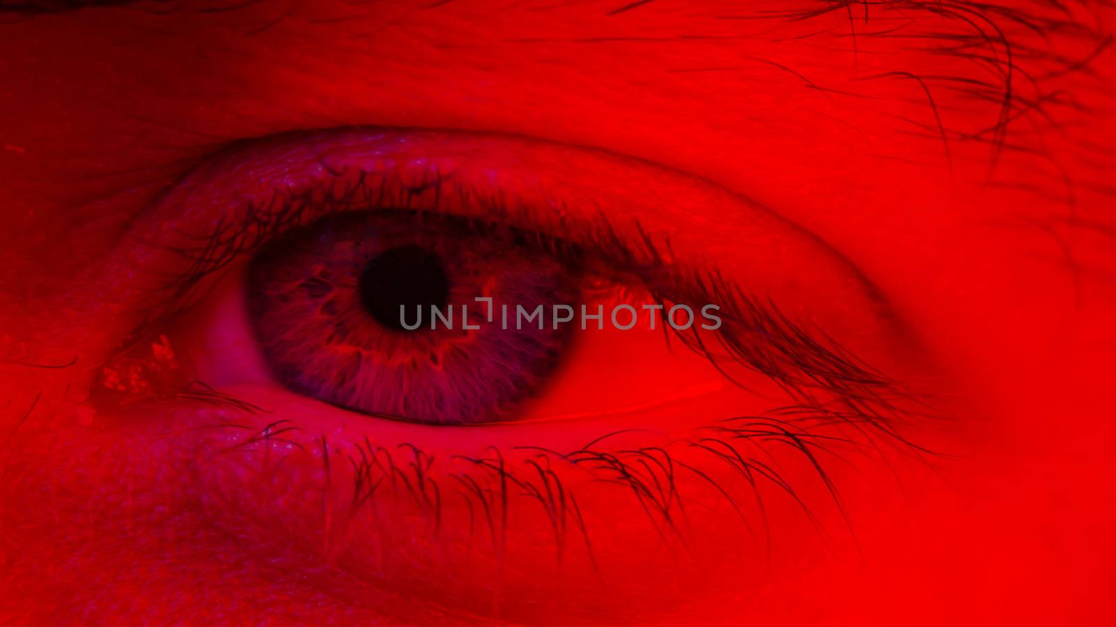 Macro on man eye expressing serious and expressionless expression.