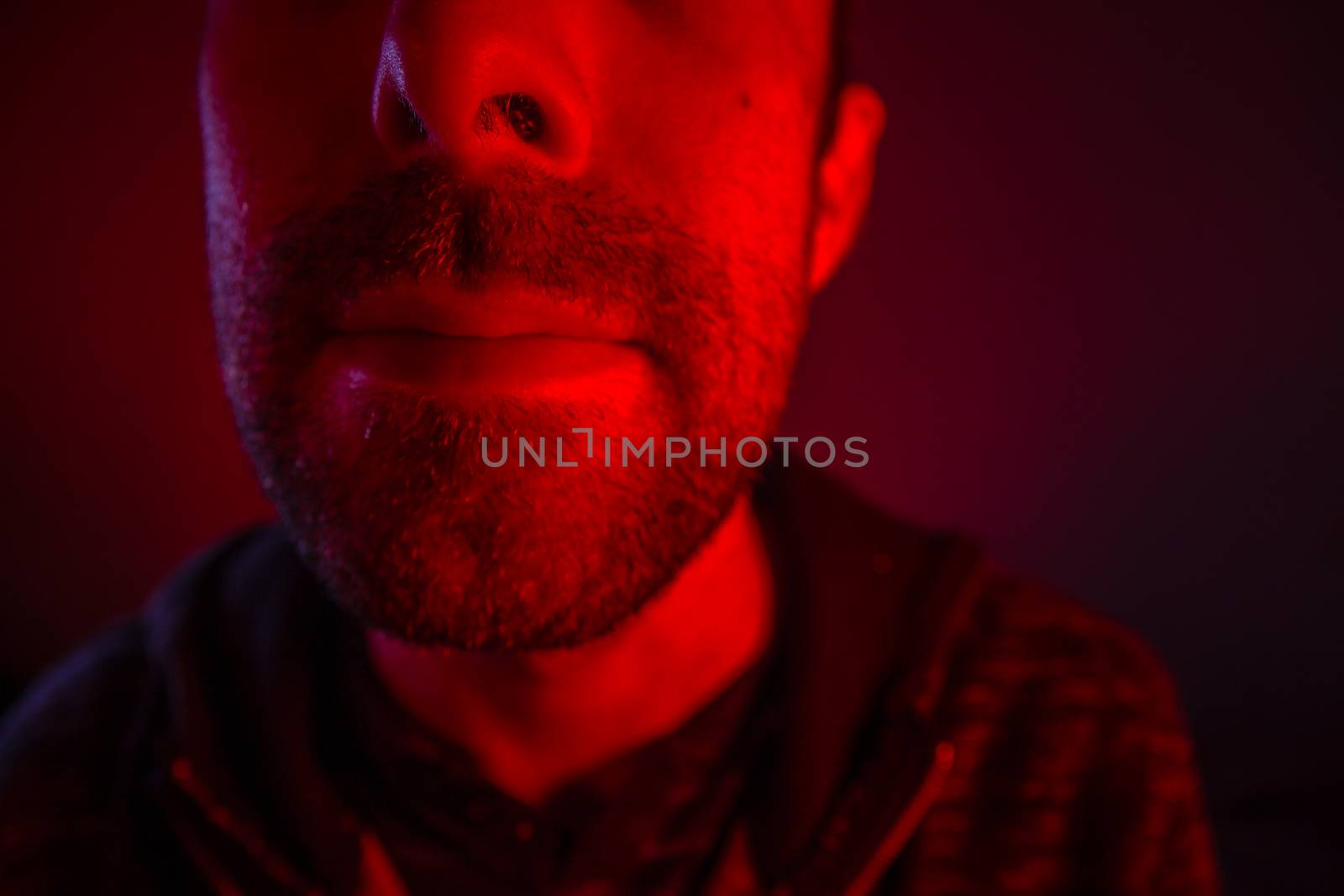 Close up on man face with serious facial expression. Portrait of expressionless young man.