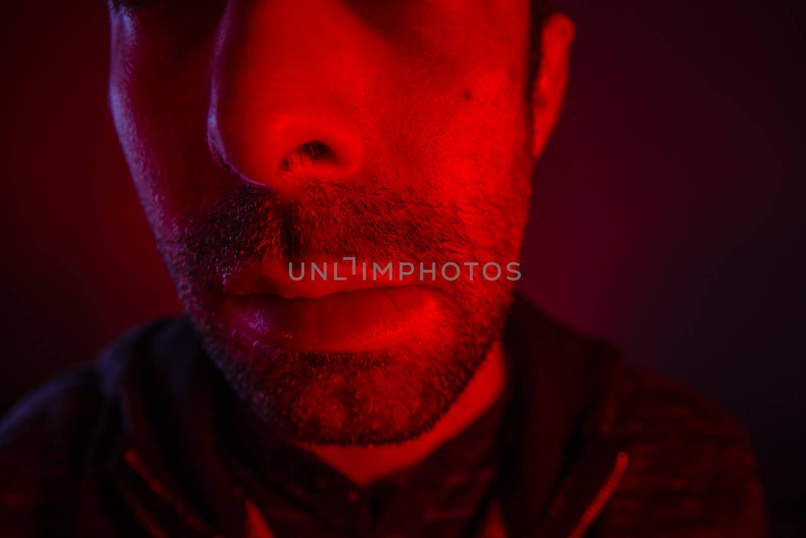 Close up on man face with serious or regret facial expression. Portrait of expressionless young man.