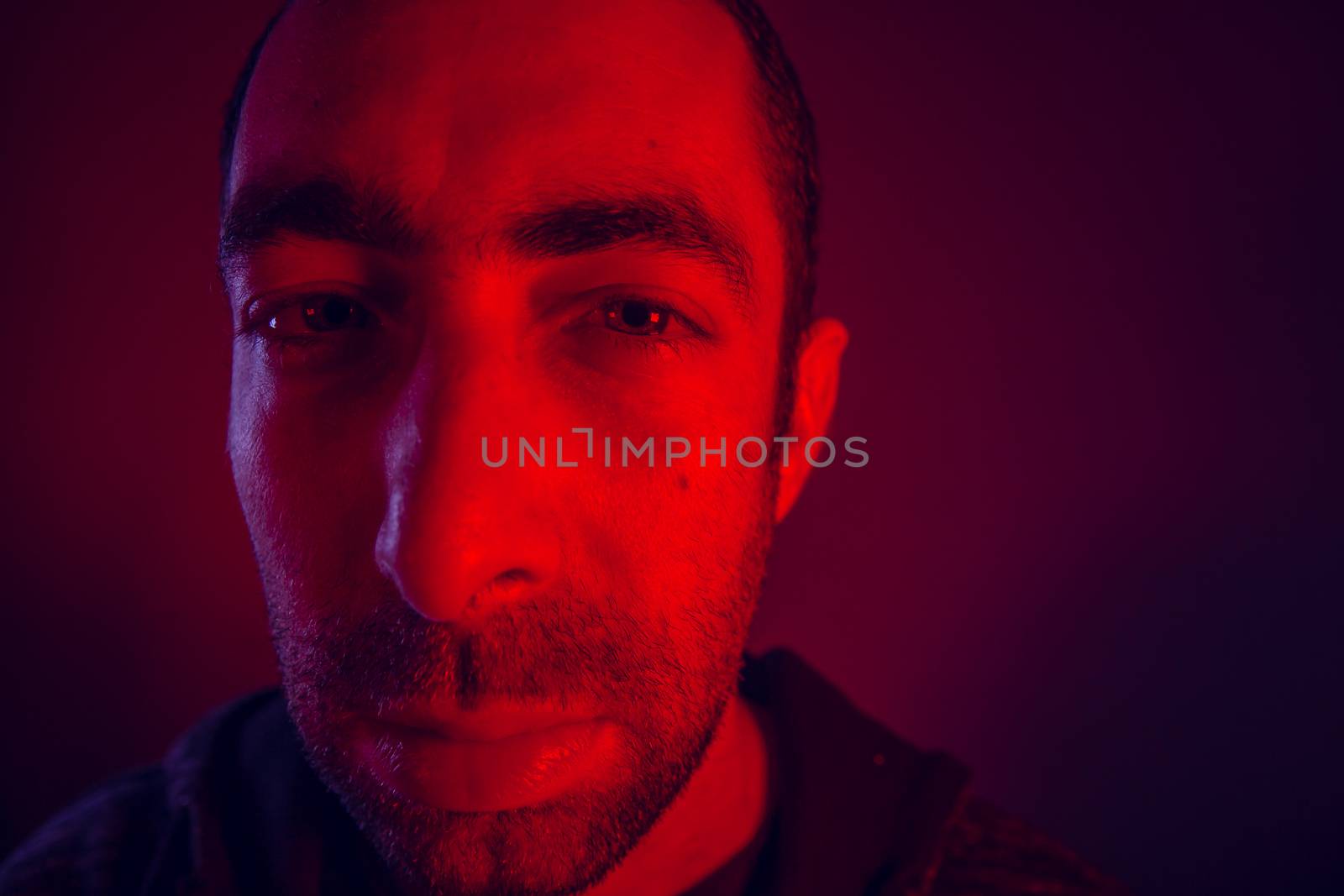 Man with serious facial expression. Close up portrait of expressionless young man.