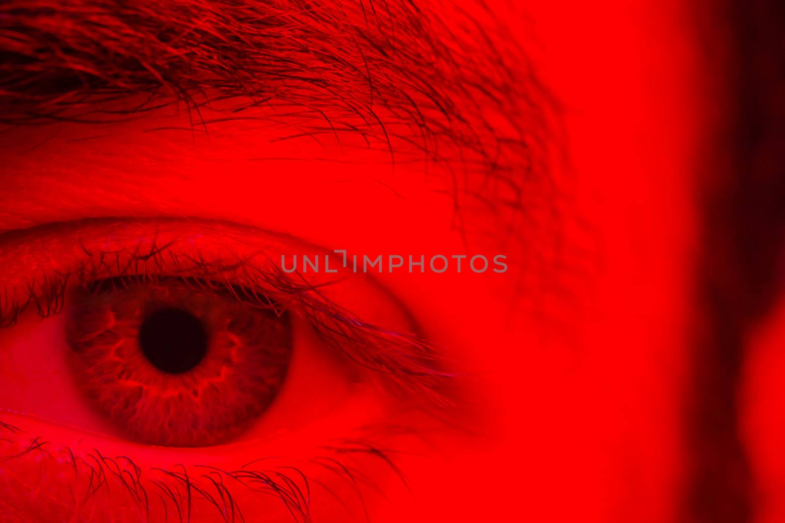 Macro on man eye expressing serious and expressionless expression.