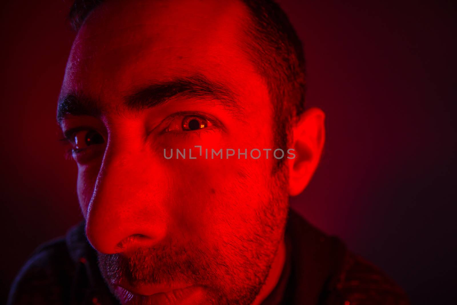 Man with suspicious facial expression. Close up portrait of doubt or skeptical young man. Also look like he is peeping.