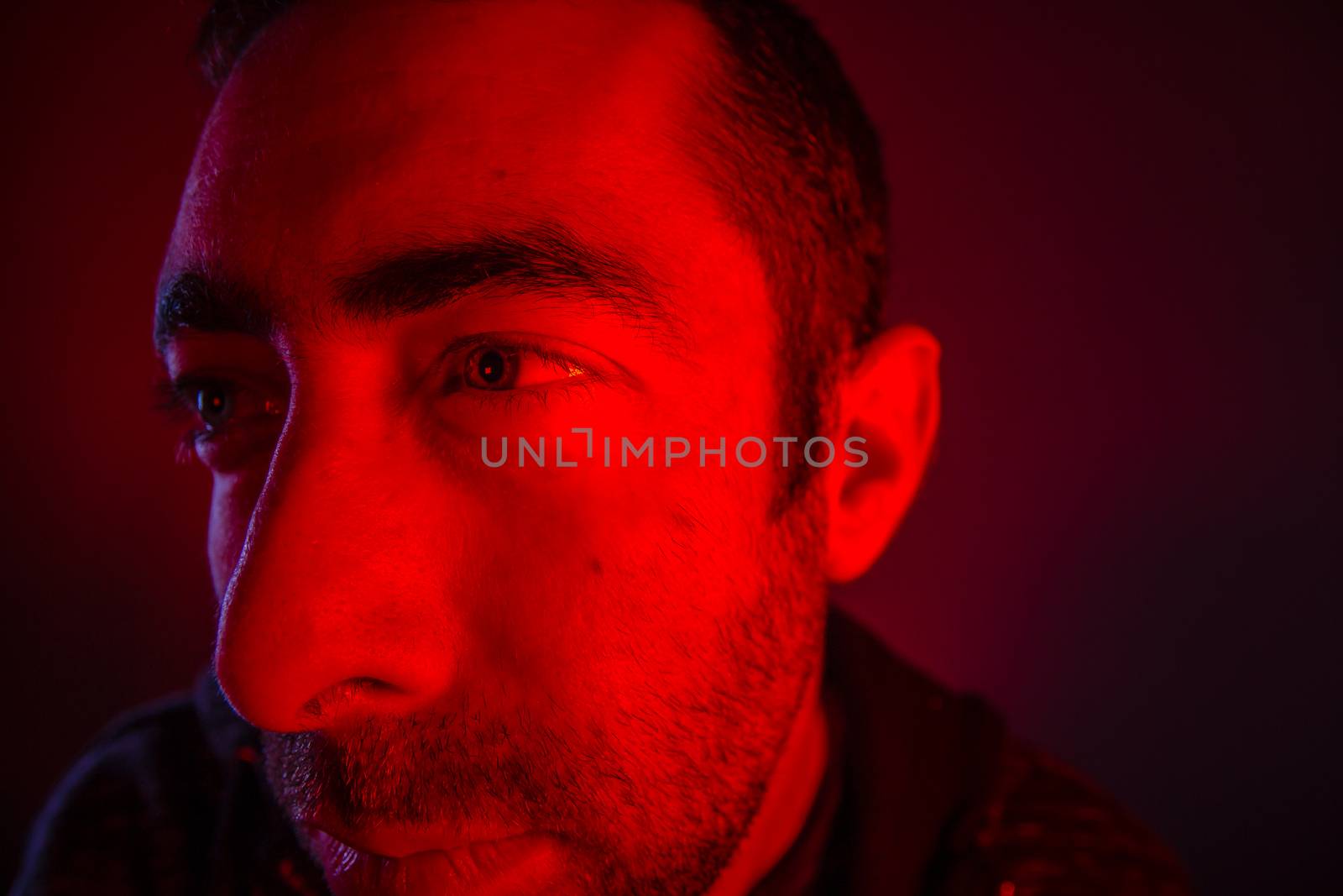 Man with serious facial expression look a side. Close up portrait of thinking young man.