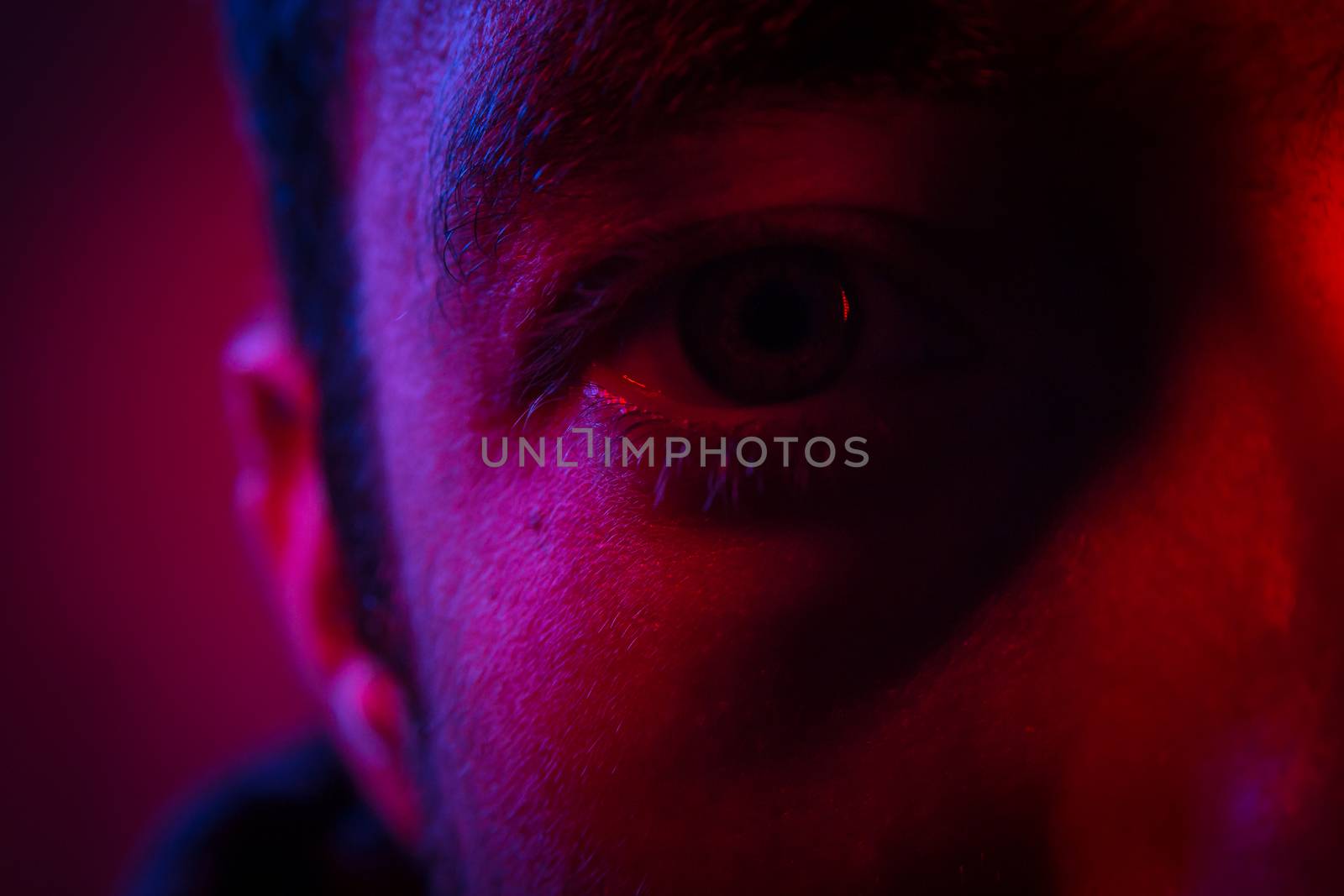 Close up on man face with mysterious facial expression. Portrait of suspicious young man.