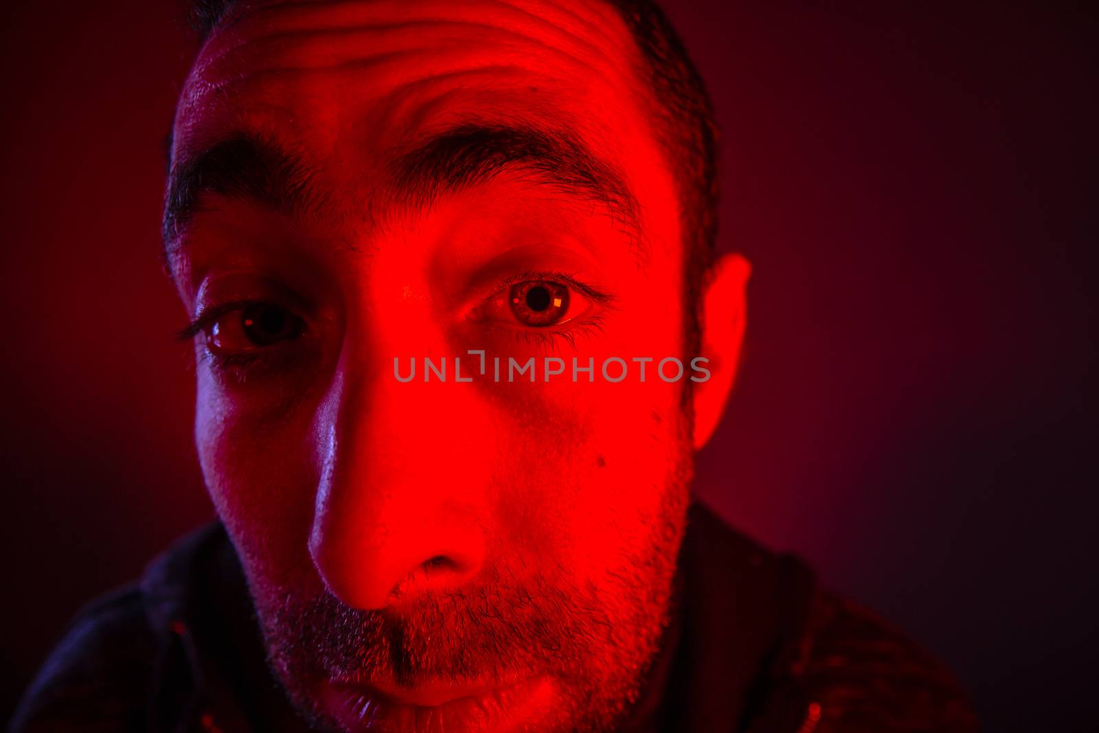 Man with suspicious facial expression. Close up portrait of doubt or skeptical young man. Also look like he is peeping.