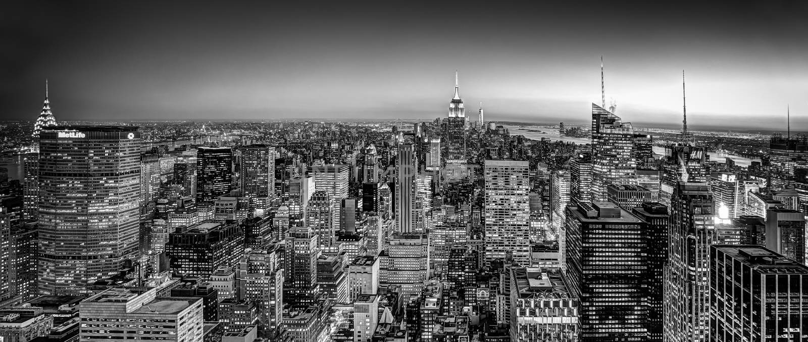 New York City. Manhattan downtown skyline with illuminated Empire State Building and skyscrapers at dusk. USA. Black and white image.