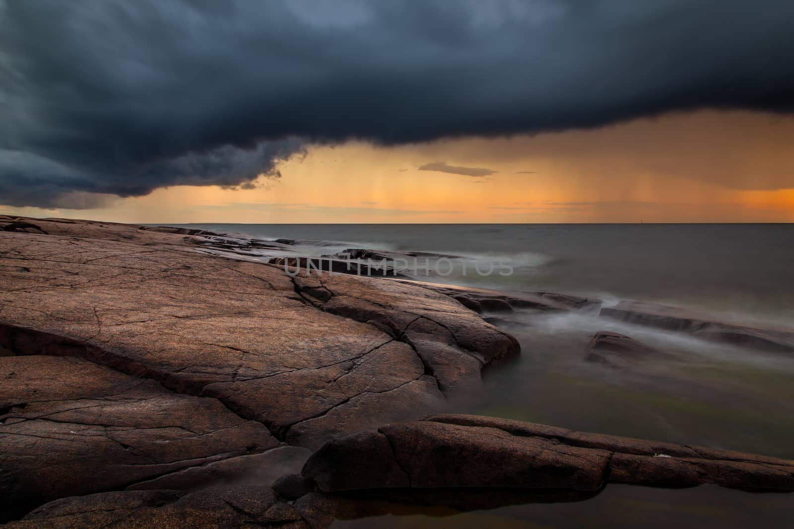 A sunset image with very dark rain clouds. The picture is taken in Pori, Finland.