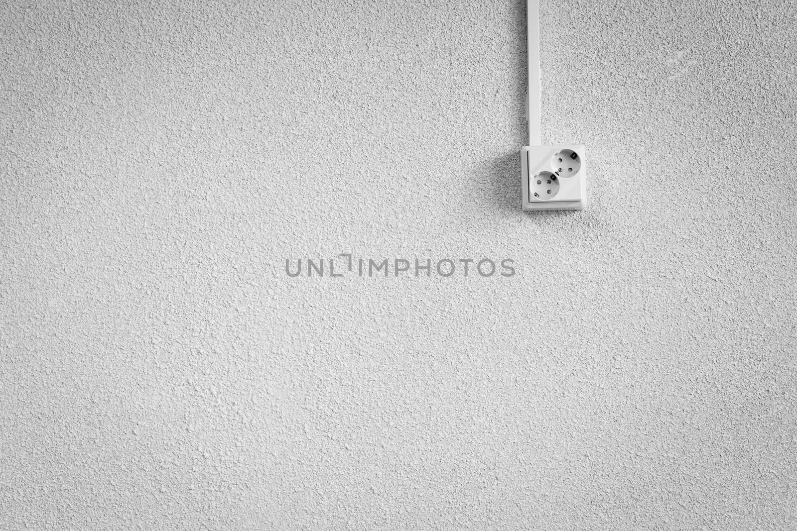 Socket on a white wall. Lots of empty space.