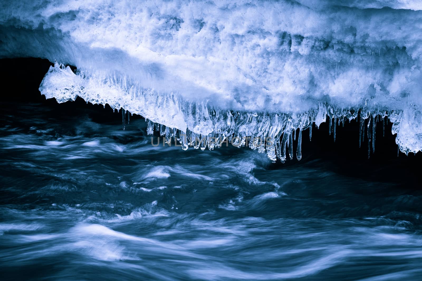 Flowing water beneath the ice. The picture shows blue tones.