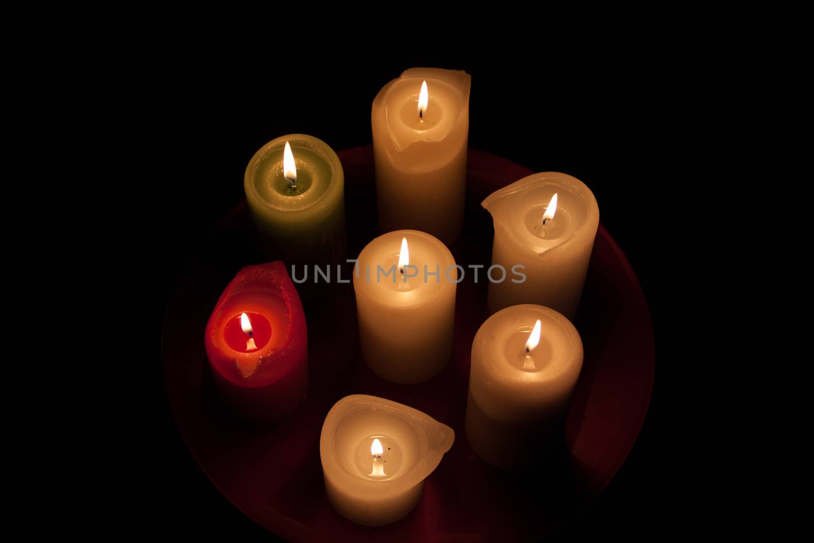 Seven candles on the table. The background is dark.