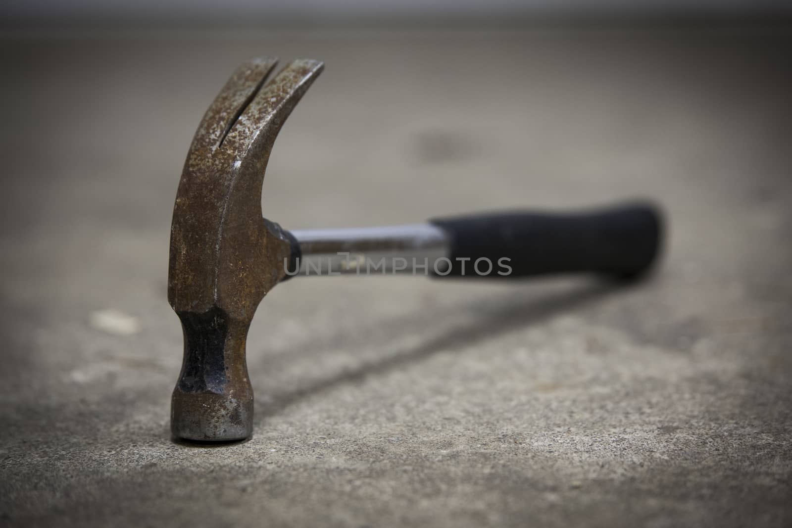 Old rusty hammer lying on the floor. A great tool even though it is old-fashioned.