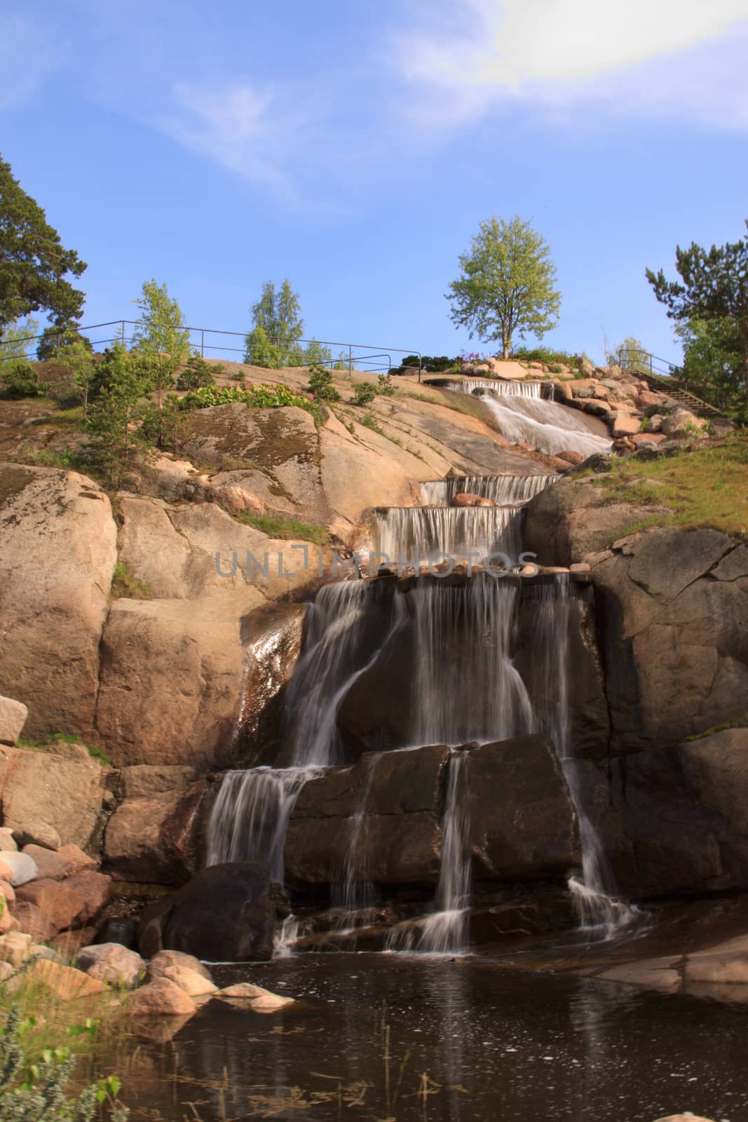 Little waterfall in Kotka, Finland. Beautiful warm day and blue sky.