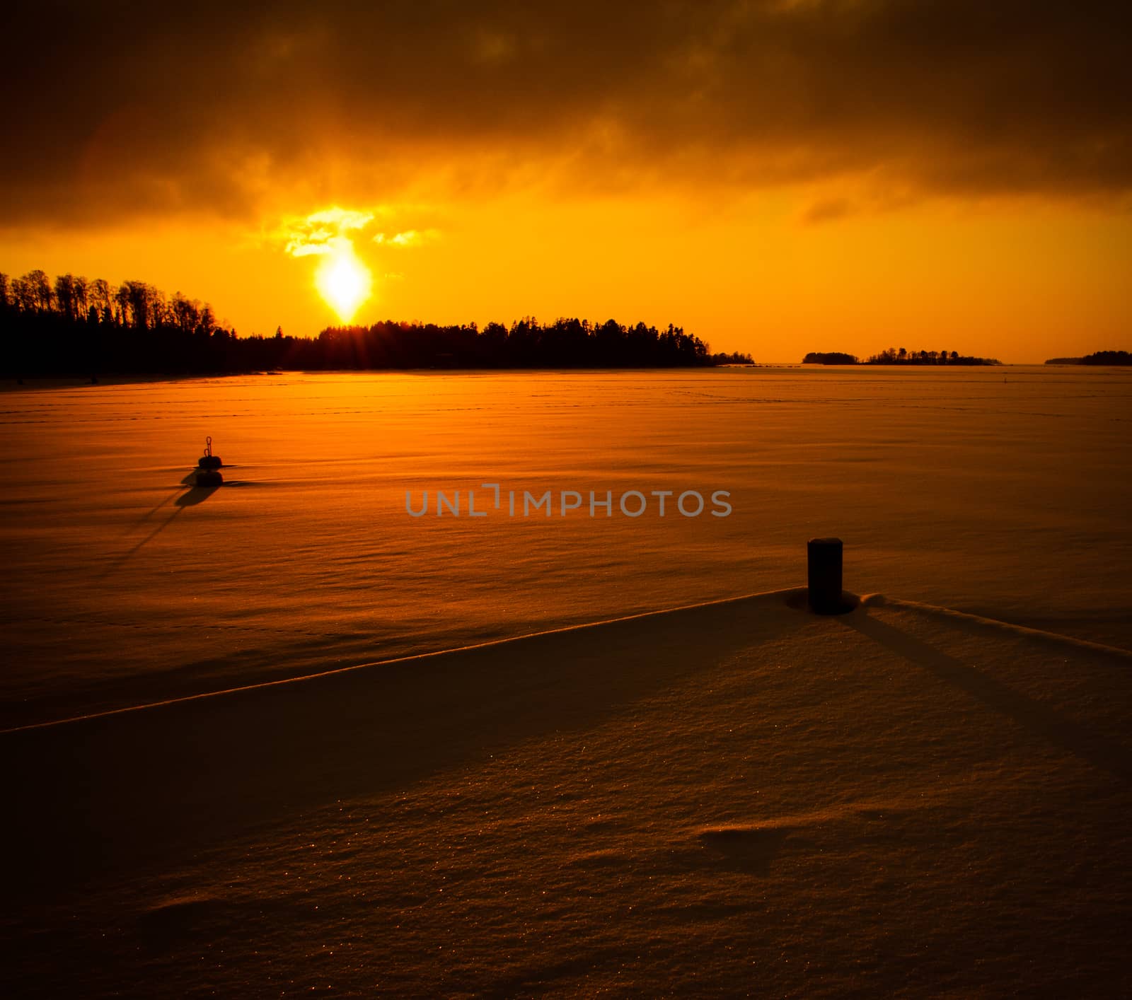 Very orange sunset in Luvia, Finland. The sea is frozen.