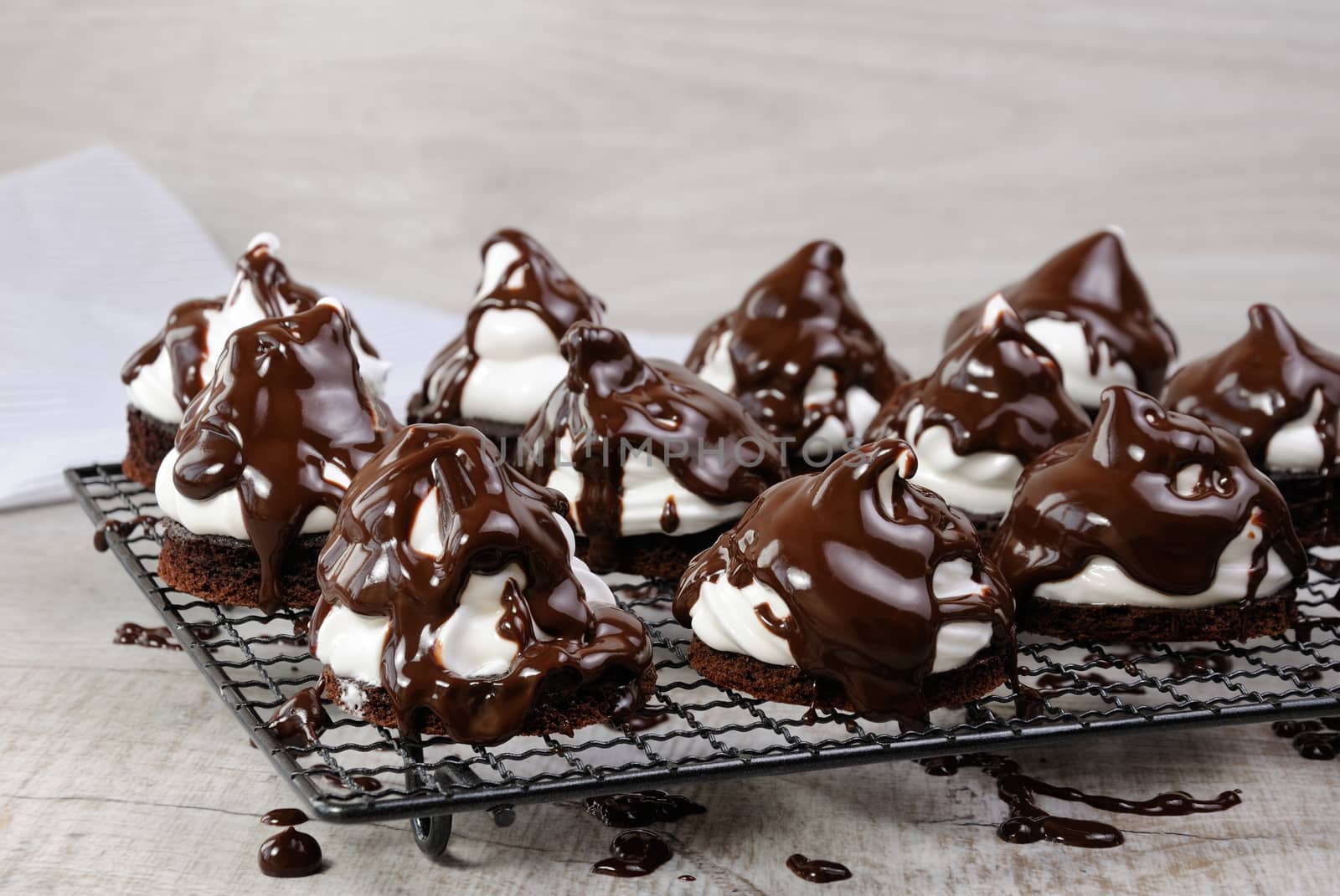 Delicate chocolate chip cookies with airy Italian meringue under chocolate glaze on the rack
