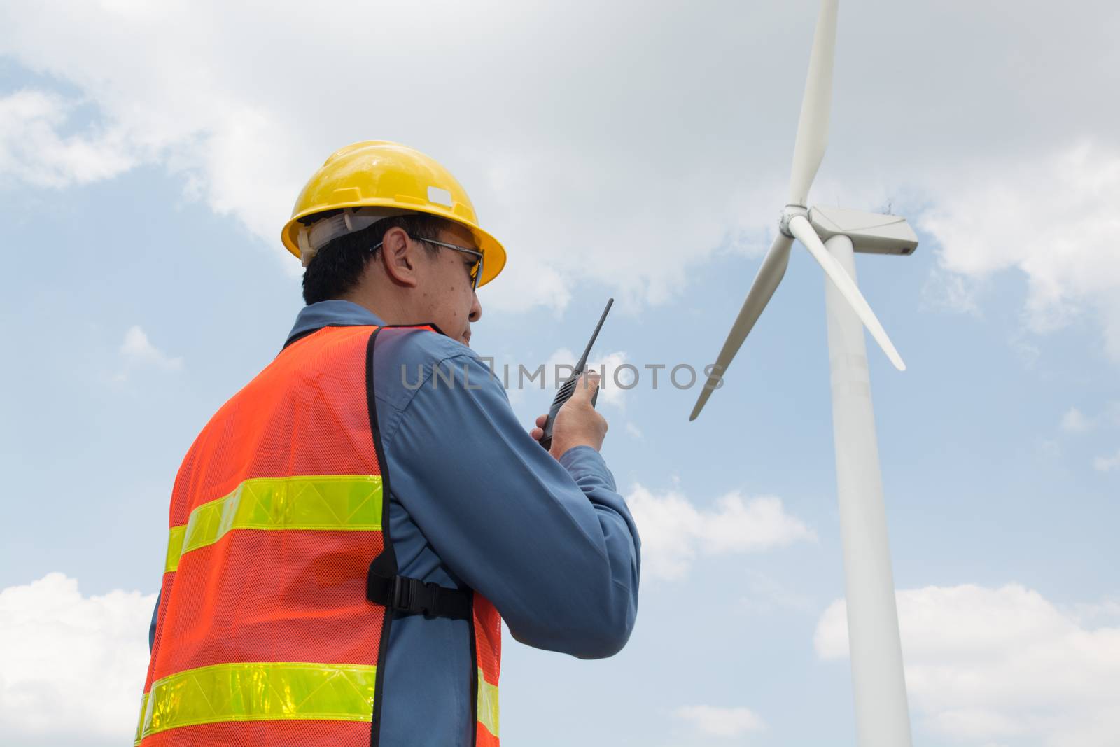 Telecommunication or Construction Equipment Concept, Male Architect or Engineer use Two way Radio to Communicate with Headquarter or Site working in Wind Turbine Power Generator Field