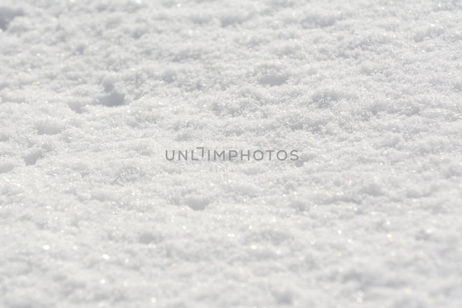 Fluffy fresh white snow sparkling in sunlight, as an abstract winter background