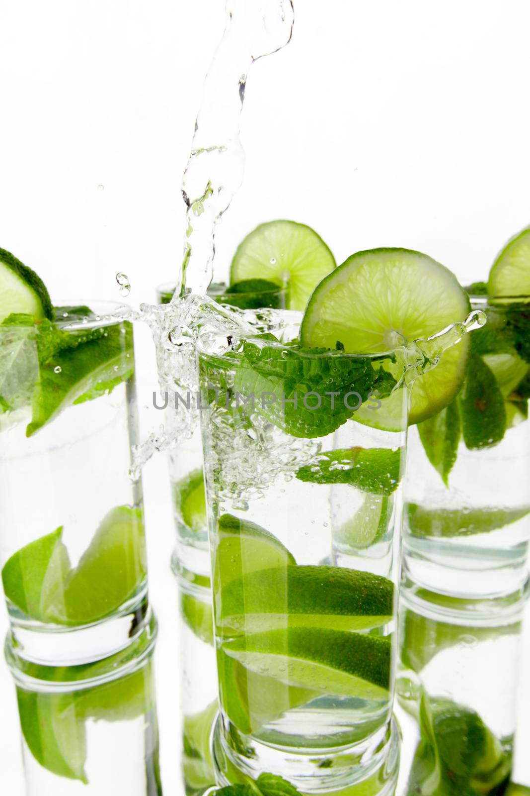 Making mojito cocktails with lime and mint isolated on white background