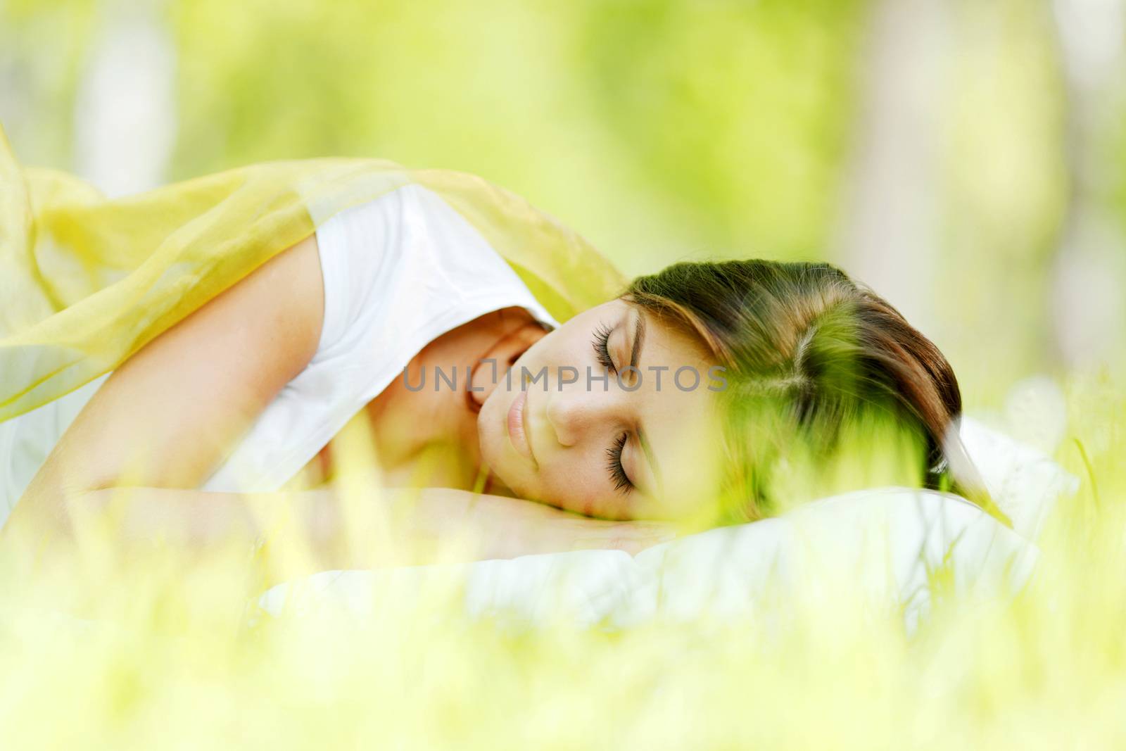 Beautiful young woman sleeping on grass outdoors