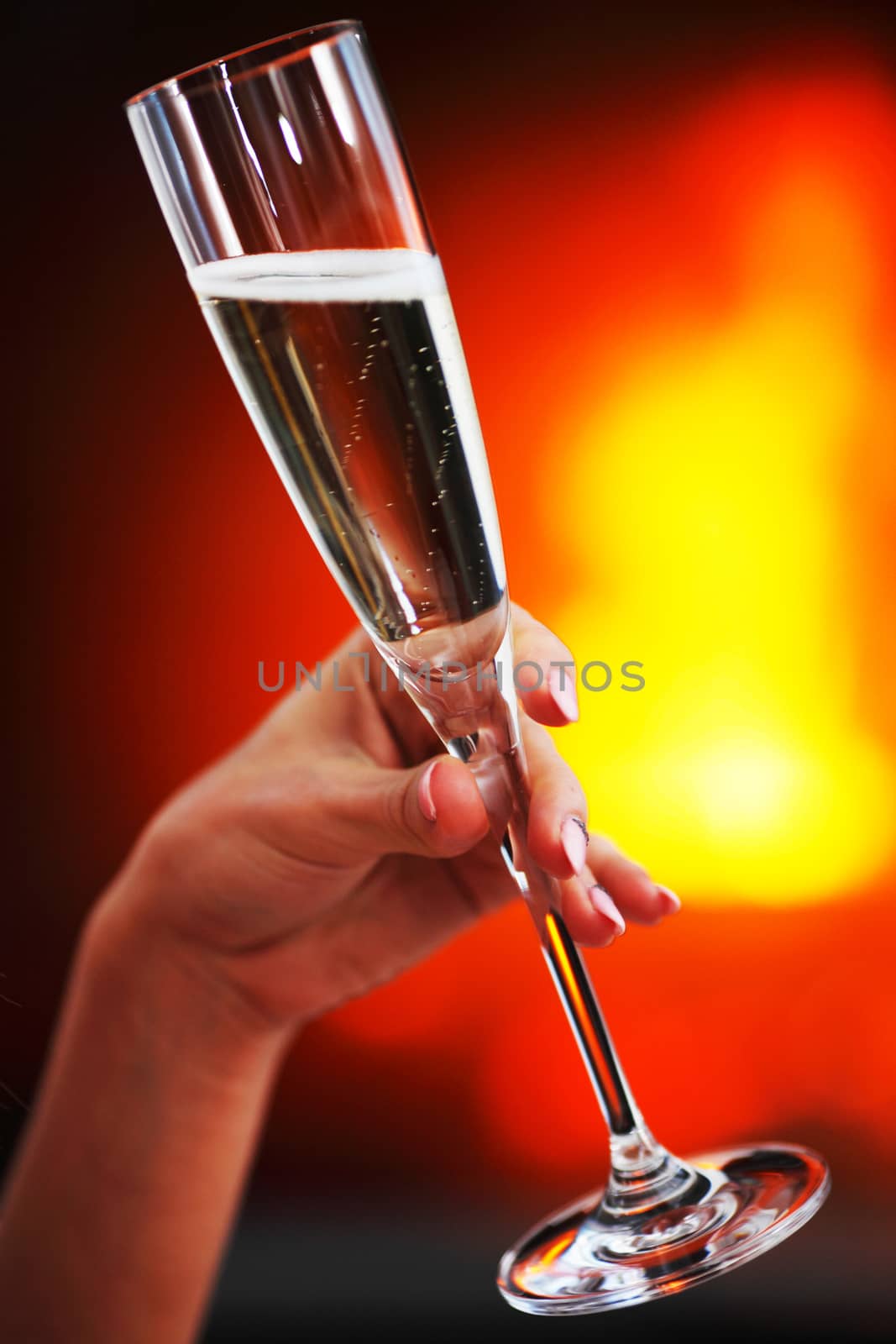 Champagne in woman hand on fireplace background