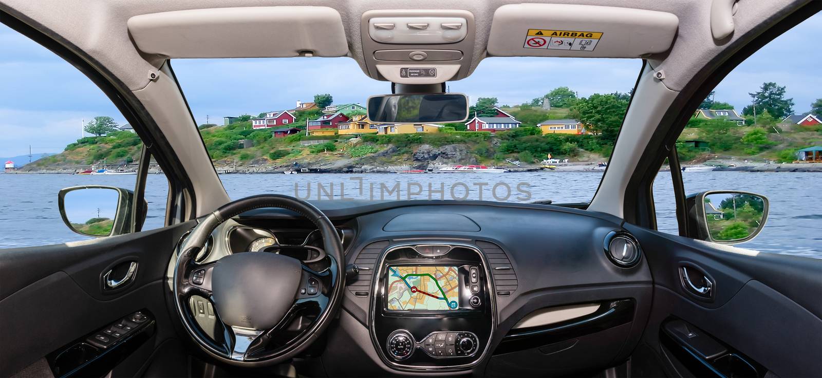 Looking through a car windshield with view over colorful houses on the shore of Oslo fjord, Oslo, Norway
