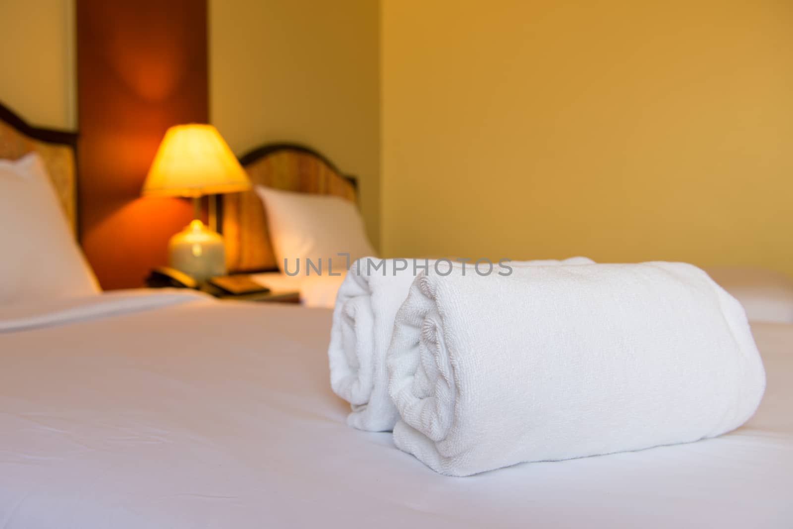 Clean towels on white bed, selected focus