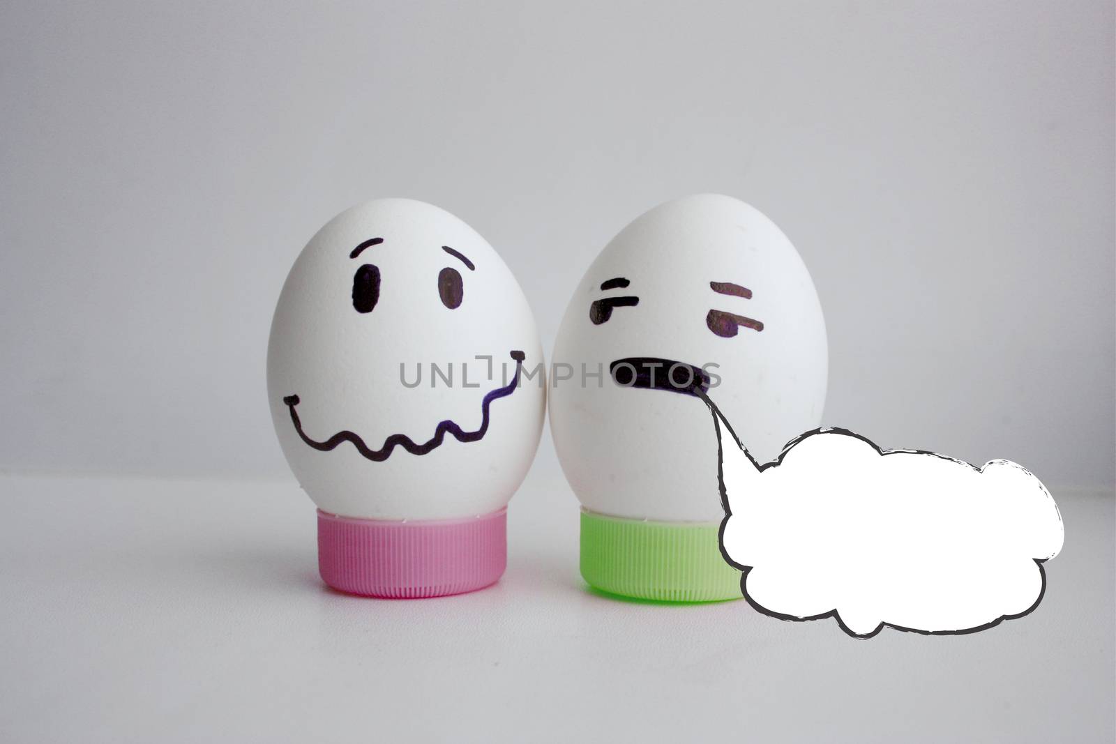 White cloud of thought is empty. Place under the text. Eggs cheerful with two face on white background on stand concept of conversation. Photo for your design