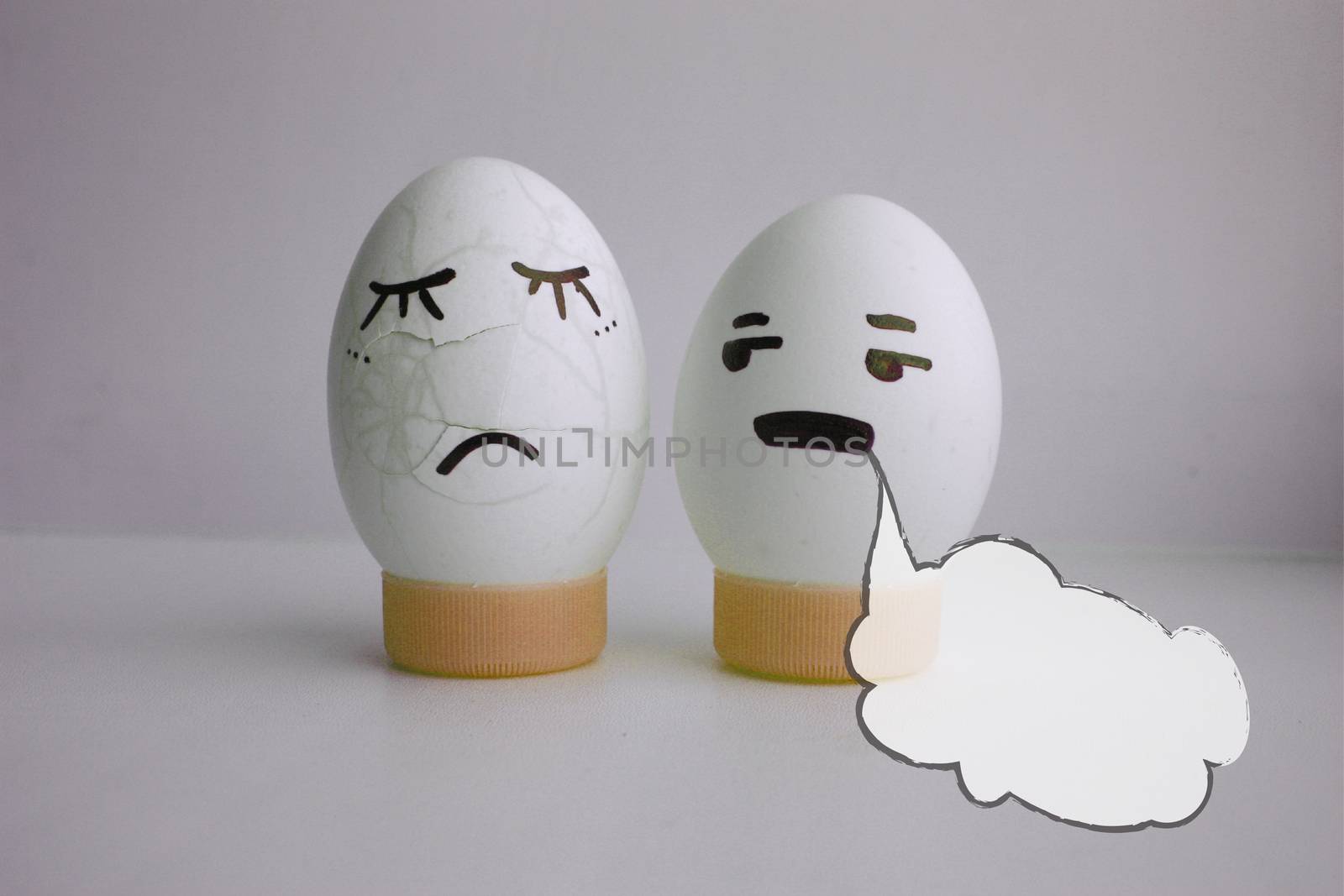 White cloud of thought is empty. Place under the text. Eggs are funny with a face on the stand. Concept of fatigue. Photo for your design on a white background