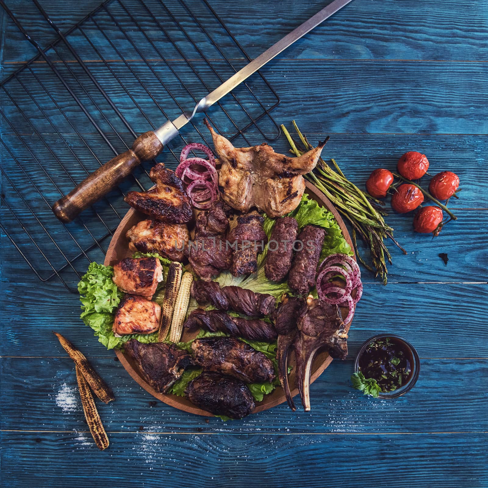 Grilled different meat set with vegetable on a blue wooden background