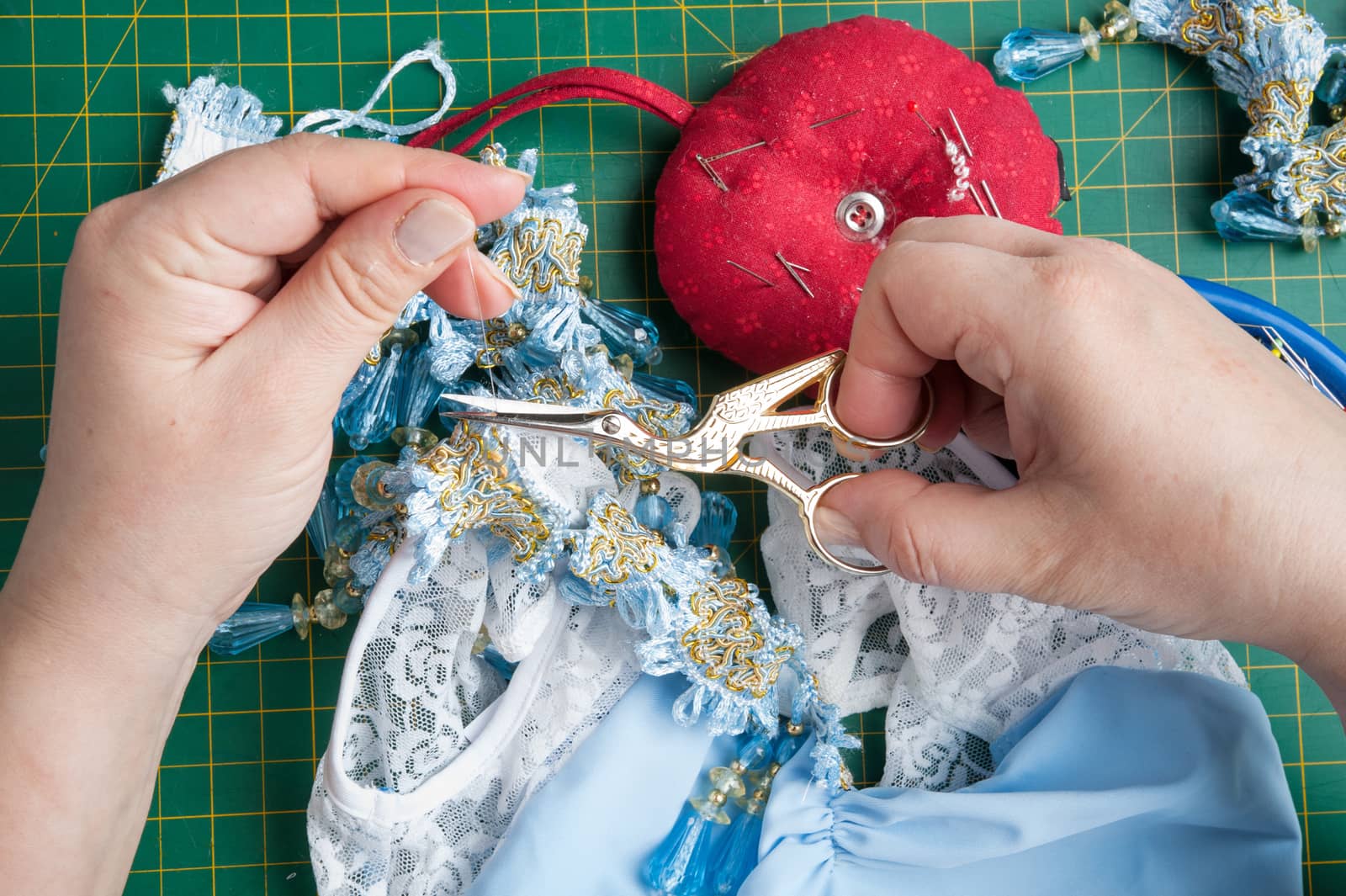 seamstress cuts the thread with sewing scissors