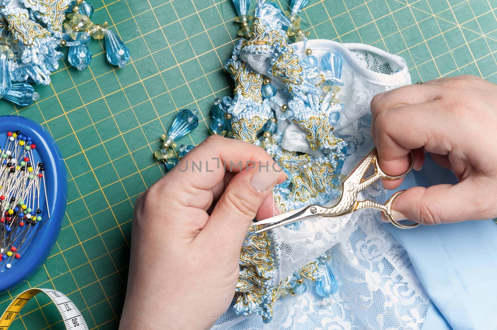 seamstress cuts the thread with sewing scissors