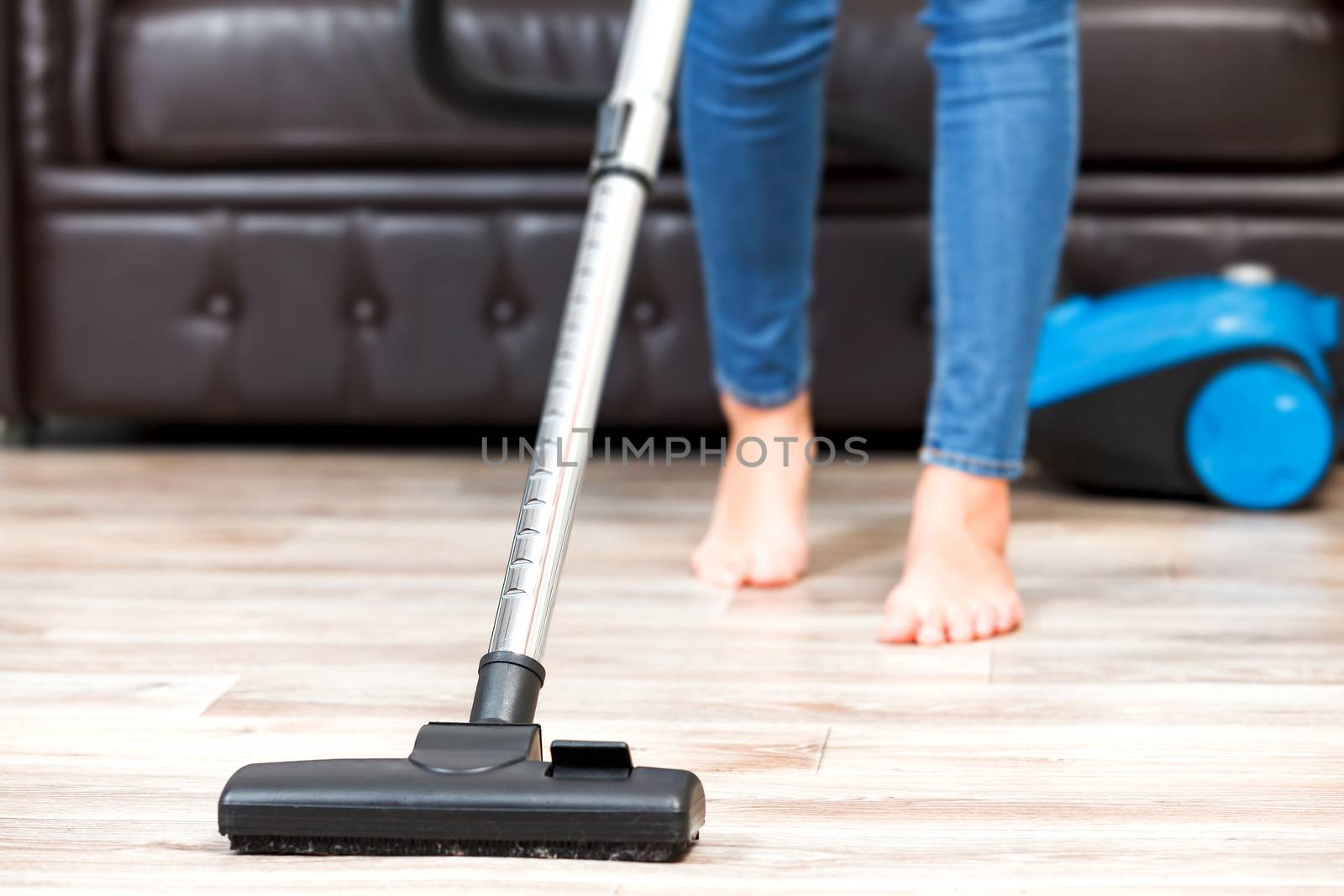 Young woman vacuum cleaning the apartment, housework by Nobilior