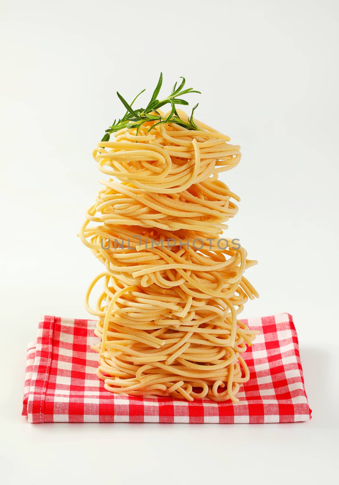bundles of uncooked spaghetti pasta on checkered place mat