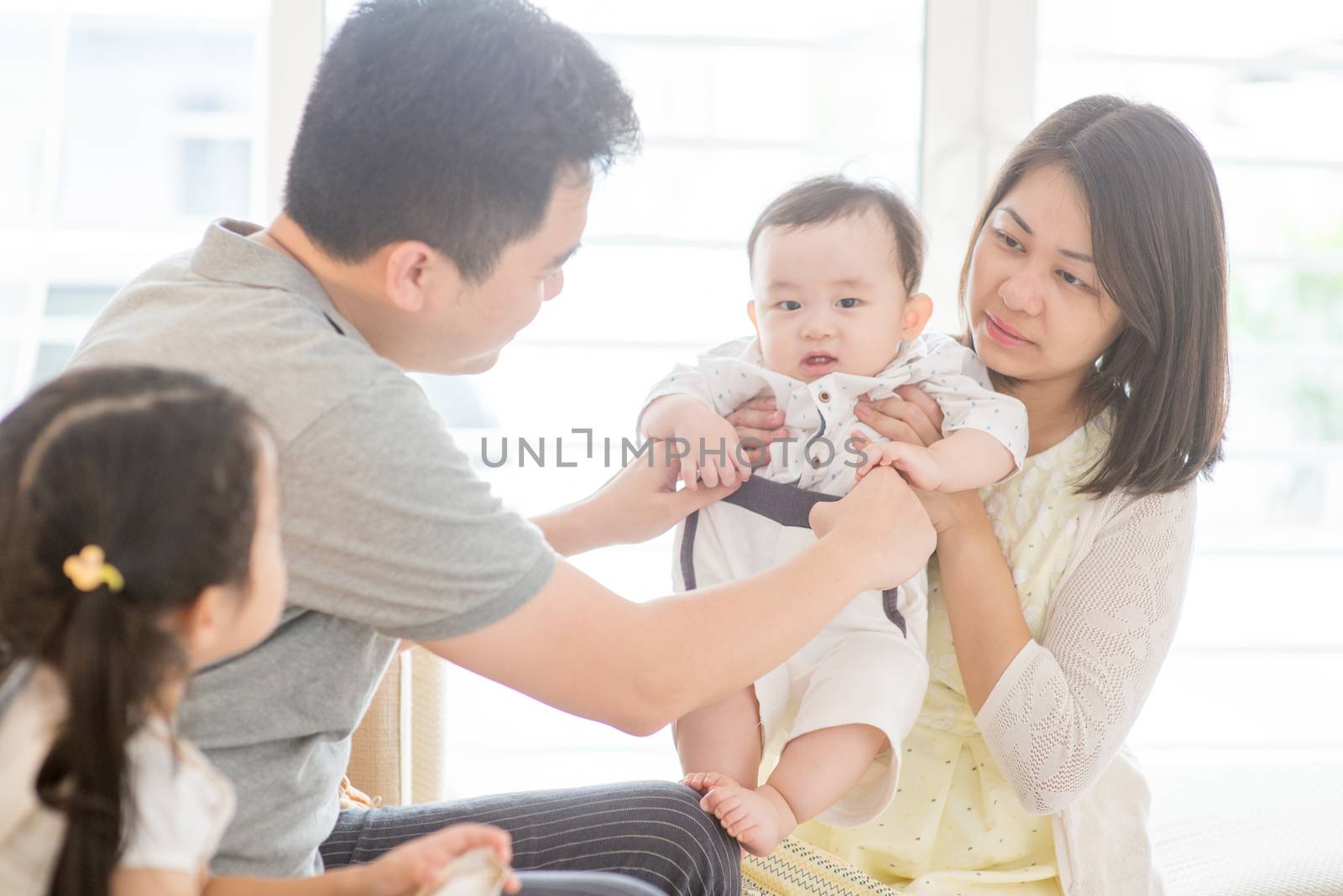 Happy Asian family at home, parents and children, natural living lifestyle indoors.