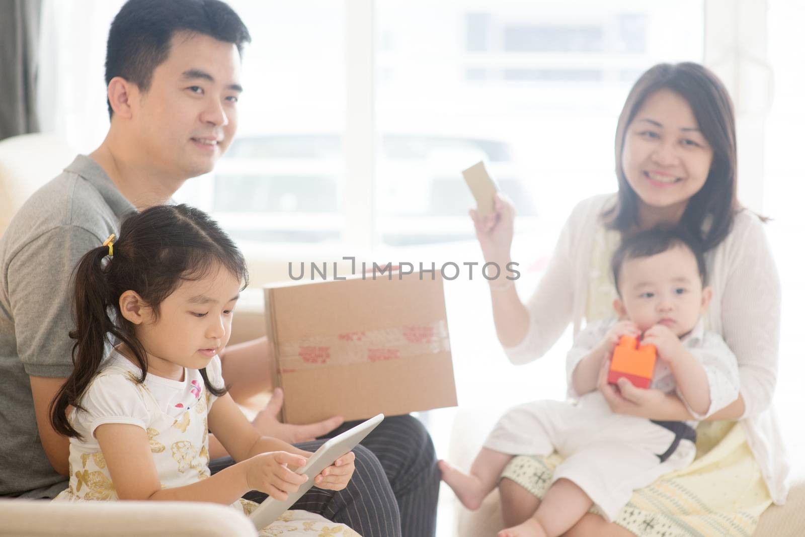Online shopping using digital tablet pc and payment with credit card. Happy Asian family at home, natural living lifestyle indoors.