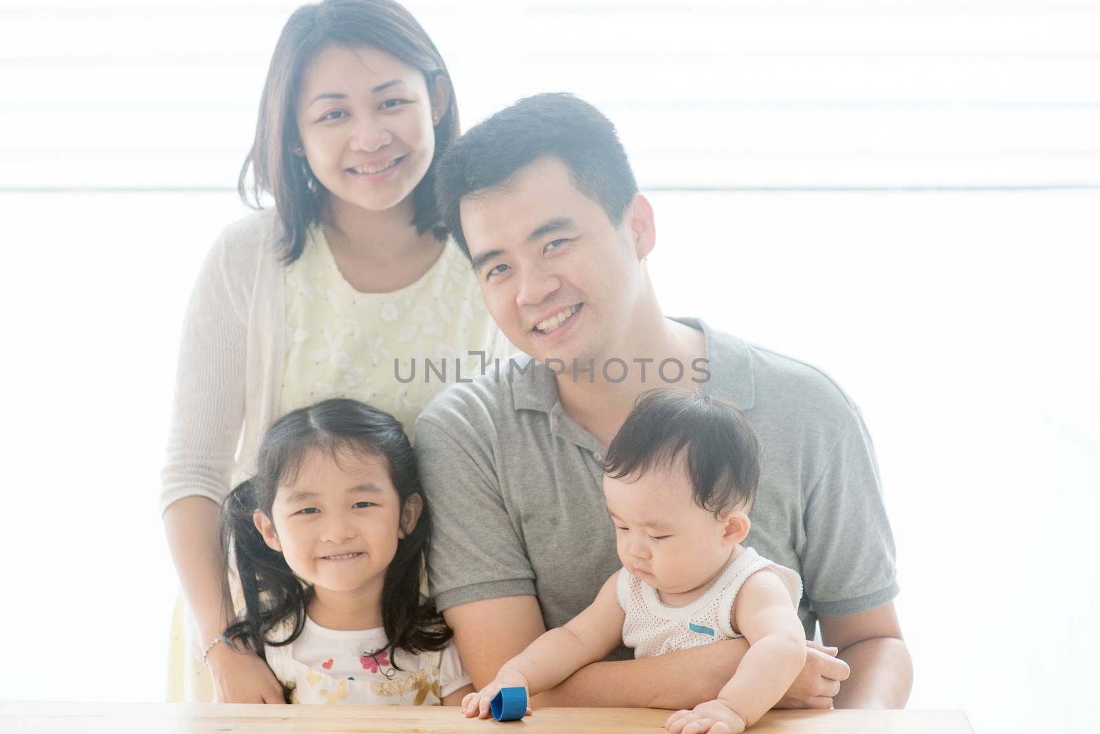 Attractive parents and children. Happy Asian family spending quality time at home, natural living lifestyle indoors.