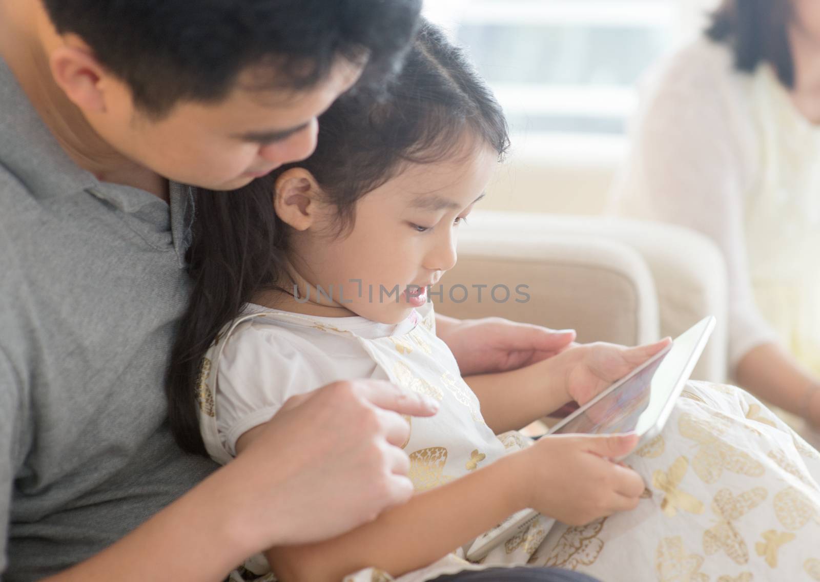 Father and daughter playing with tablet pc. by szefei