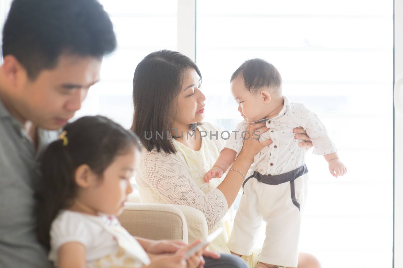 Happy Asian family at home, candid living lifestyle indoors.