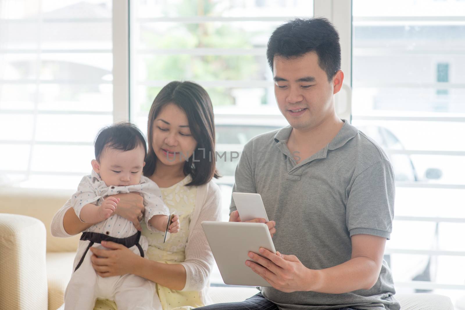 Chinese people scanning QR code with smart phone. Asian family at home, natural living lifestyle indoors.