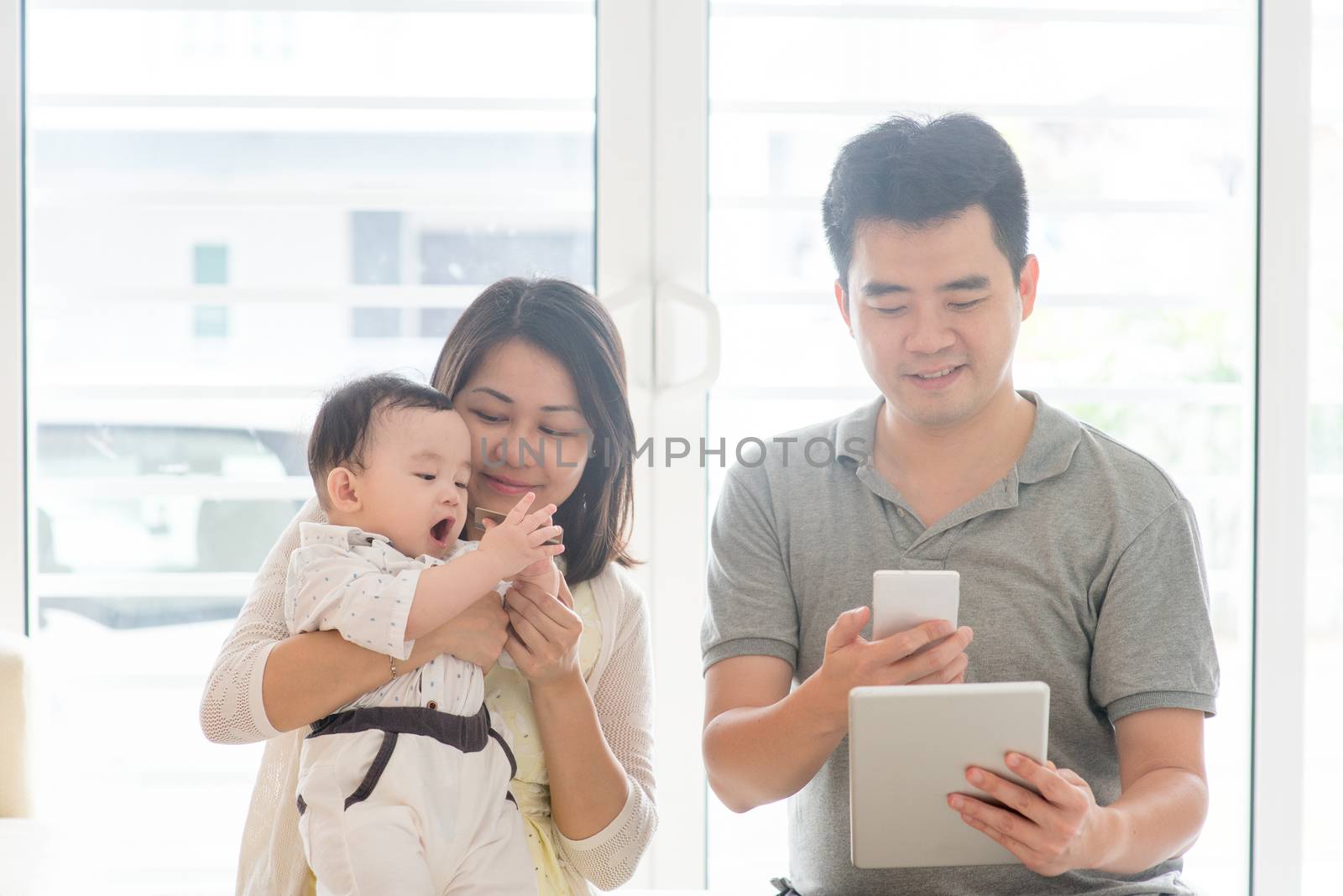 China man scanning QR code with smart phone. Asian family at home, natural living lifestyle indoors.
