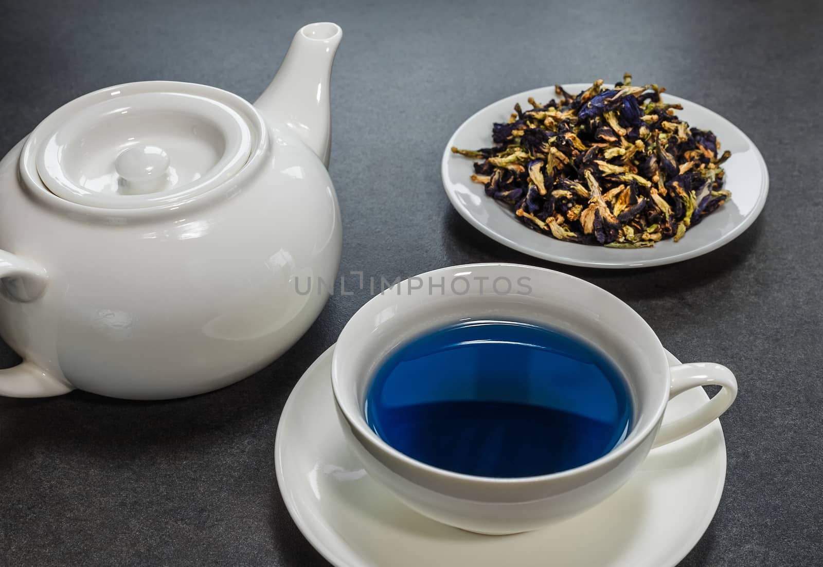 Thai blue tea in a white cup on a gray background