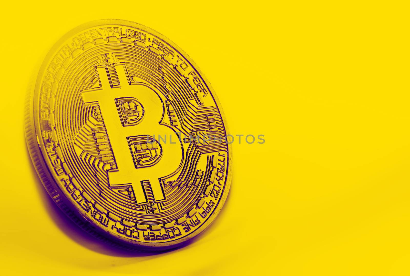 Bitcoin coin photo close-up. Crypto currency, blockchain technology on yellow background